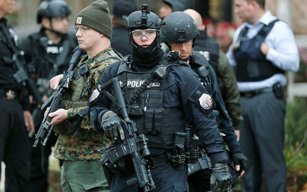 Law enforcement officers gather in front of a home near the scene of a shooting, Wednesday, Nov. 2, in Urbandale, Iowa. (AP Photo/Charlie Neibergall)
