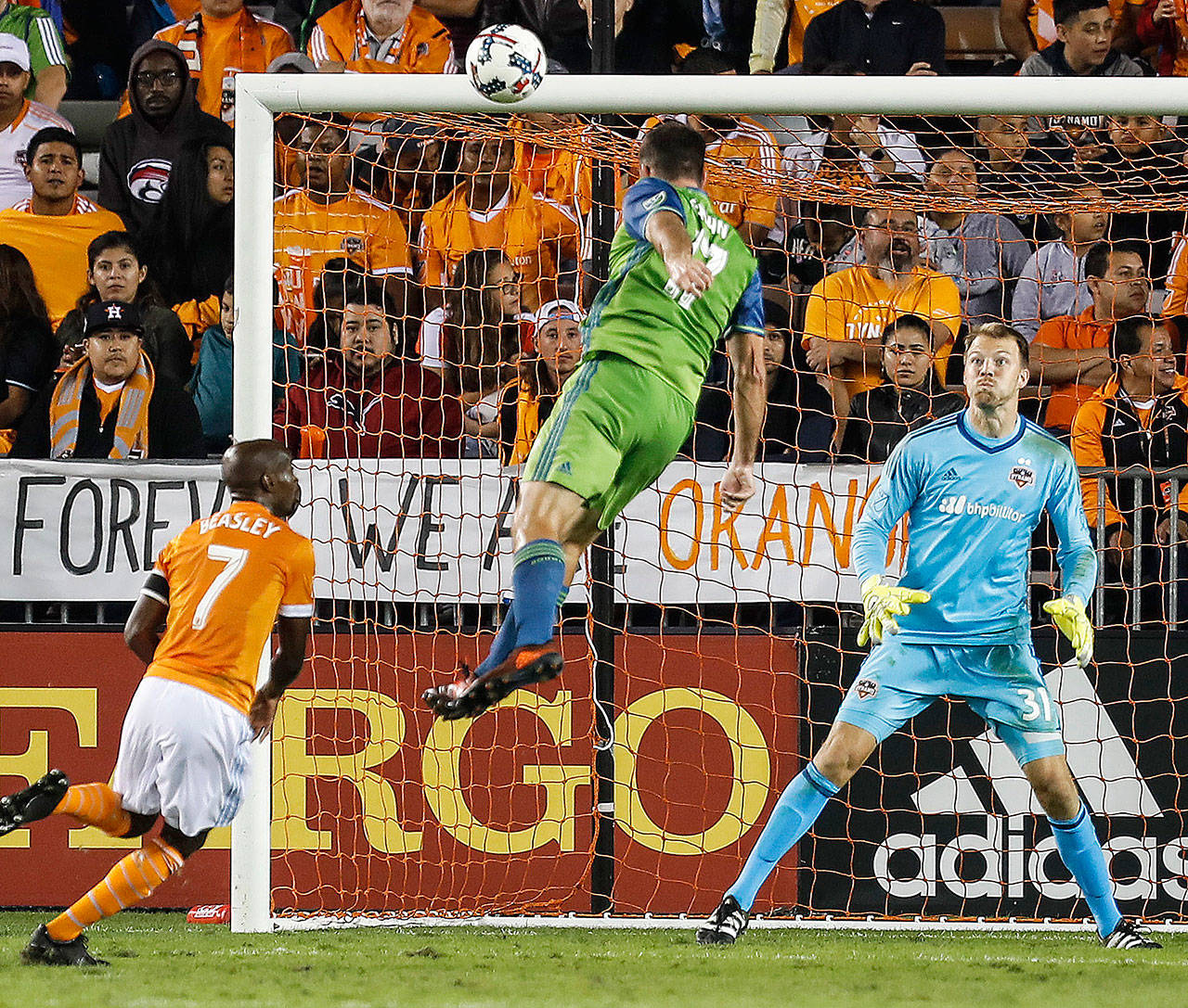 Seattle’s Will Bruin (17) heads a goal past Houston’s Joe Willis (31) during the first half of the Sounders’ 2-0 victory over the Dynamo in the first leg of the Western Conference finals Tuesday in Houston. (Brett Coomer/Houston Chronicle via AP)