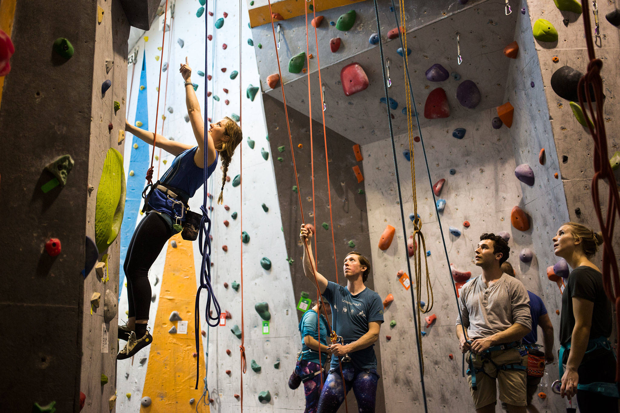 Brenna Anderst points up at her route as fellow climbers Zach Graham, James Boreson and Amy Boreson listen and give advice at Summit Everett on Tuesday. (Andy Bronson / The Herald)