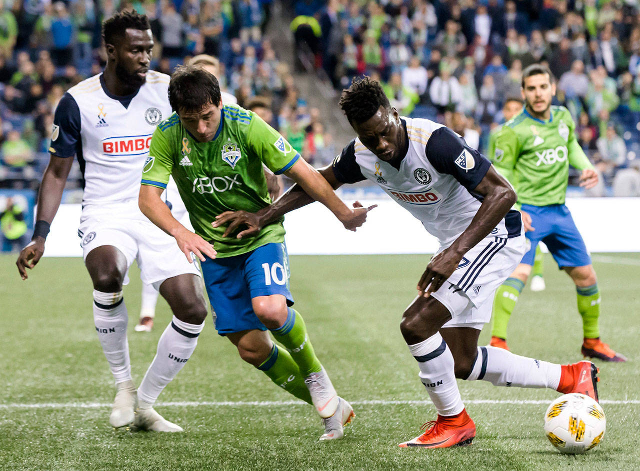 Sounders midfielder Nicolas Lodeiro (10) loses the ball to Union forward C.J. Sapong on the edge of the box during the first half of an MLS match on Sept. 19, 2018, in Seattle. (Bettina Hansen/The Seattle Times via AP)