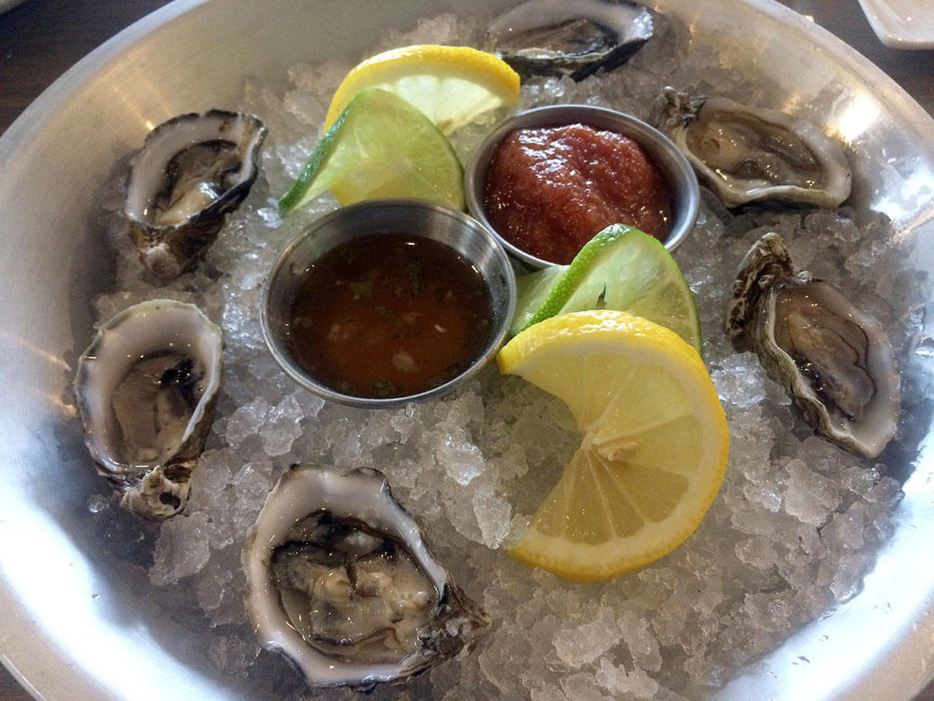 Empty Shell has six different types of oysters. Pictured here at the takara oysters, farmed in Willapa Bay, which are chilled and served with cocktail sauce and a house sauce. (Evan Thompson / The Herald)
