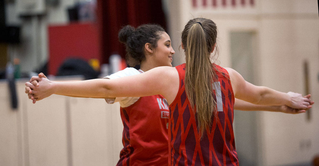 Jada Wynn, left, and teammate Emma Storkson compare arm spans during Mondays practice. (Andy Bronson / The Herald)
