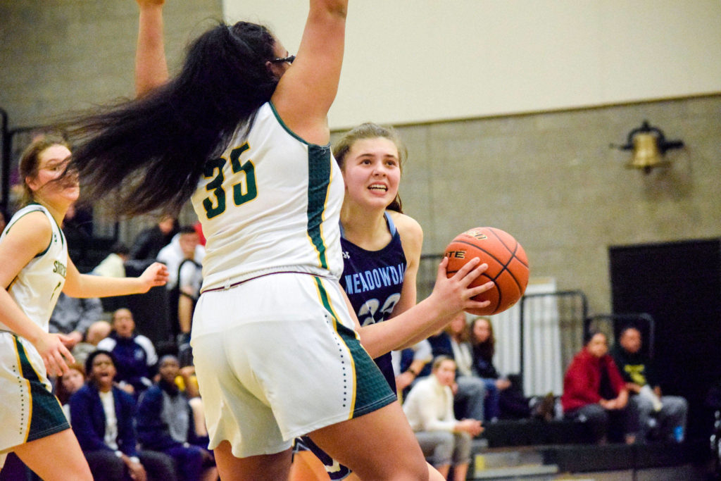 Meadowdale’s Ava Powell (right) looks up to shoot a basket against Shorecrest’s Kiana Lino on Thursday, Jan. 30 at Shorecrest High School in Shoreline. (Katie Webber / The Herald)
