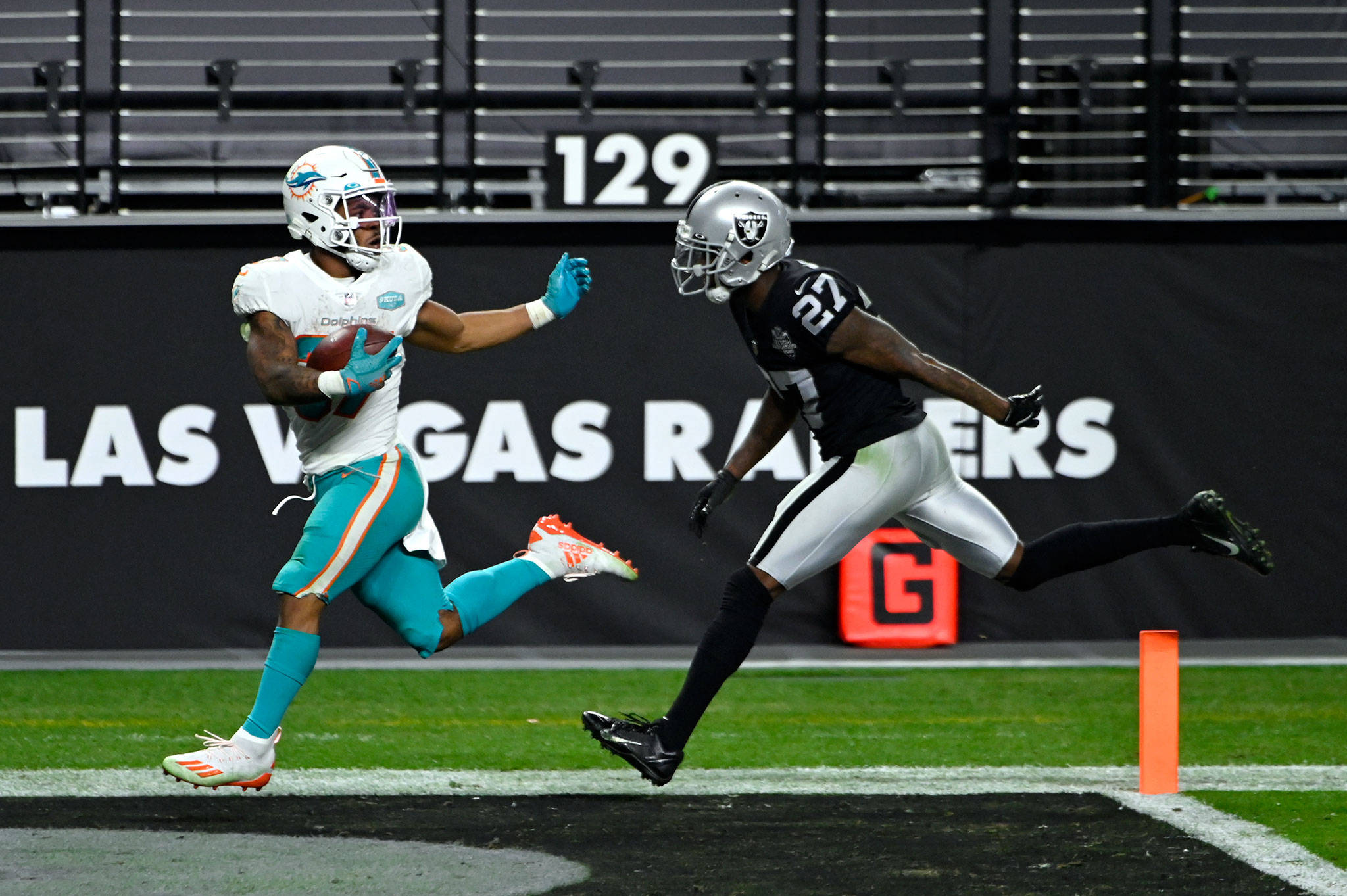 Miami Dolphins running back Myles Gaskin (37) runs past Raiders cornerback  Trayvon Mullen (27) …