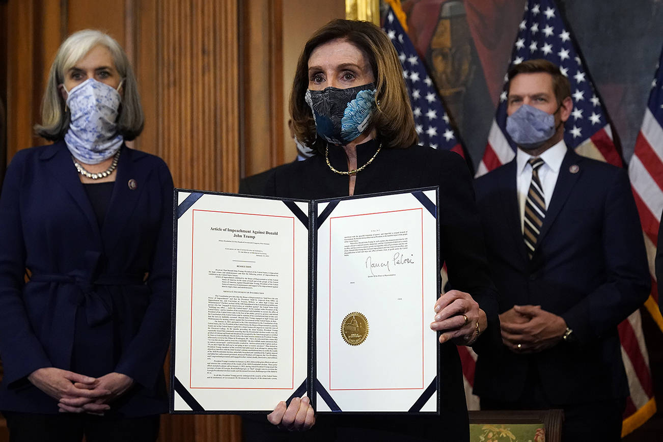 House Speaker Nancy Pelosi of Calif., displays the signed article of impeachment against President Donald Trump in an engrossment ceremony before transmission to the Senate for trial on Capitol Hill, in Washington, Wednesday, Jan. 13, 2021. (AP Photo/Alex Brandon)