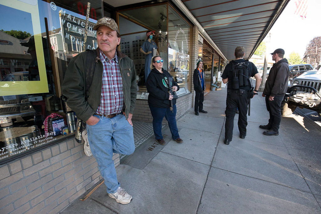 Armed citizens standing along First Street in Snohomish said they were there to protect businesses from possible looters on June 1, 2020. (Andy Bronson / Herald file) 
