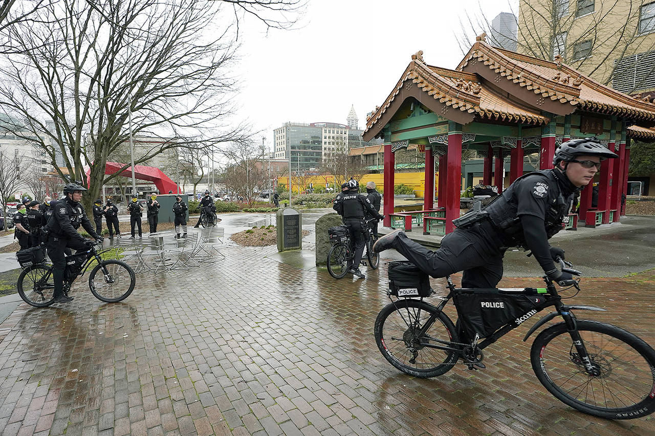 Seattle Police officers head out on bicycles after taking part in a public roll call at Hing Hay Park in the heart of Seattle’s Chinatown-International District on March 18. (AP Photo/Ted S. Warren, file)