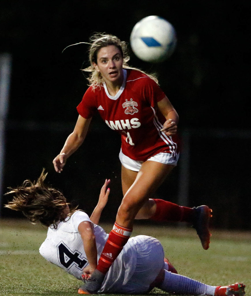 Arlington’s Maddy Stivers kicks the ball loose from Archbishop Murphy’s Taylor Campbell at Archbishop Murphy High School Tuesday night in Everett on September 14, 2021. The Wildcats won 6-1. (Kevin Clark / The Herald)
