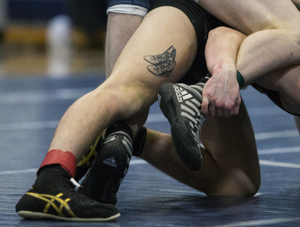 A tattoo of wrestling shoes is visible on Lake Stevens’ Tyler Flouts’ leg during a wrestling meet on Tuesday in Snohomish. (Olivia Vanni / The Herald)
