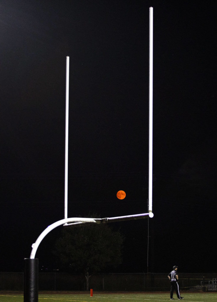 A red moon rises between the goal posts during the game between Marysville Getchell an Arlington on Friday, Sept. 9, 2022 in Marysville, Washington. (Olivia Vanni / The Herald)
