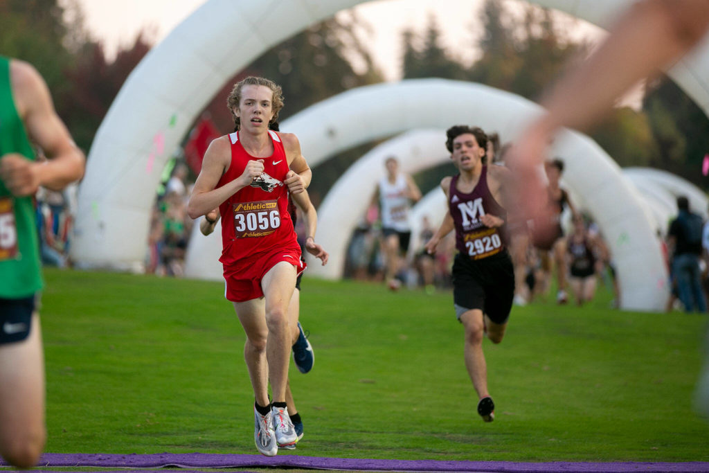 Runners cross the finish line in the 3A-4A Boys 5K during the Nike Twilight Cross Country Invitational on Saturday, Oct. 1, 2022, at Cedarcrest Golf Course in Marysville, Washington. (Ryan Berry / The Herald)
