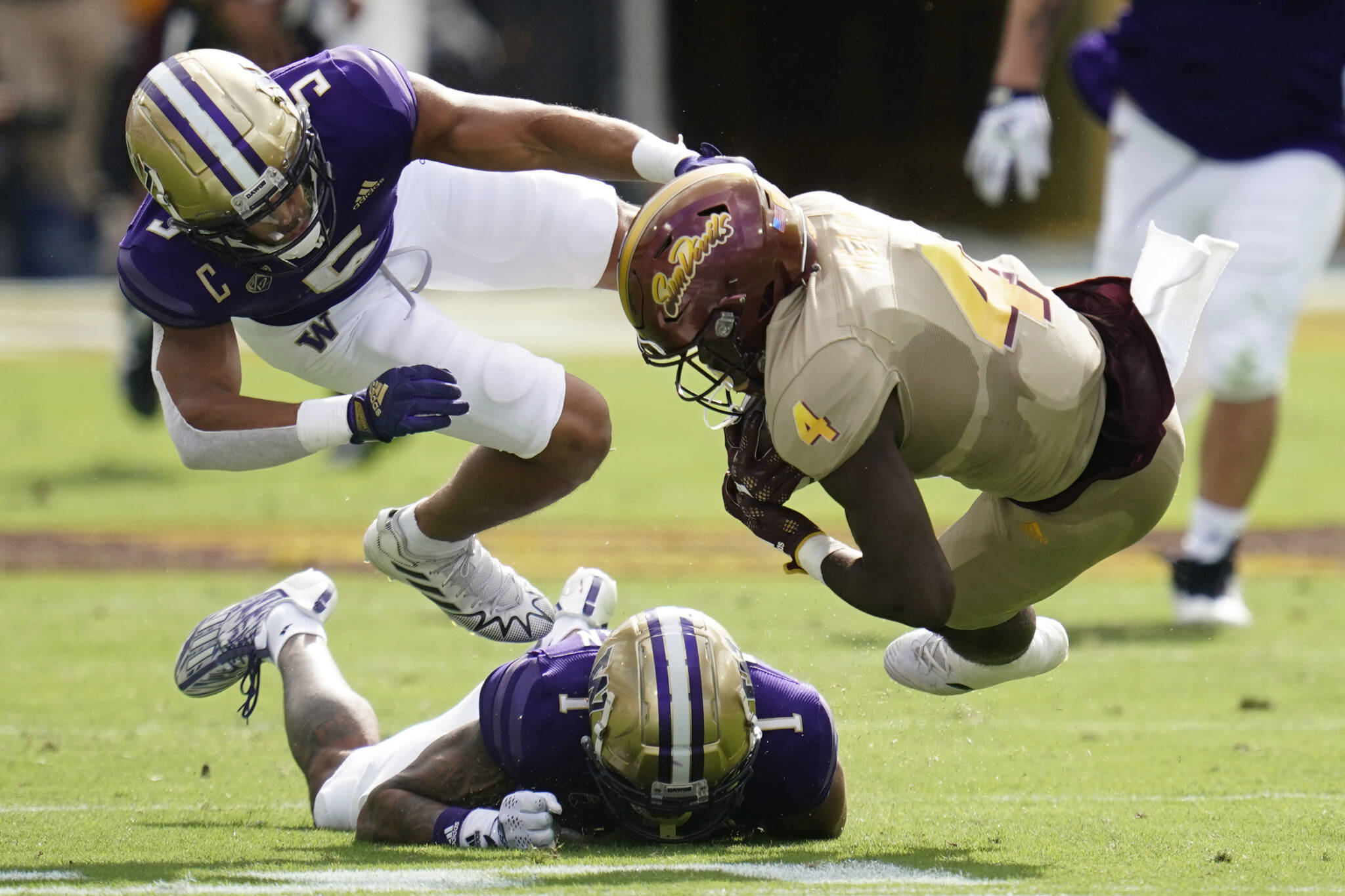 Arizona State running back Daniyel Ngata (4) is tripped by Washington safety Alex Cook (5) and cornerback Jordan Perryman (1) during the first half of a game Oct. 8 in Tempe, Ariz. (AP Photo/Ross D. Franklin)