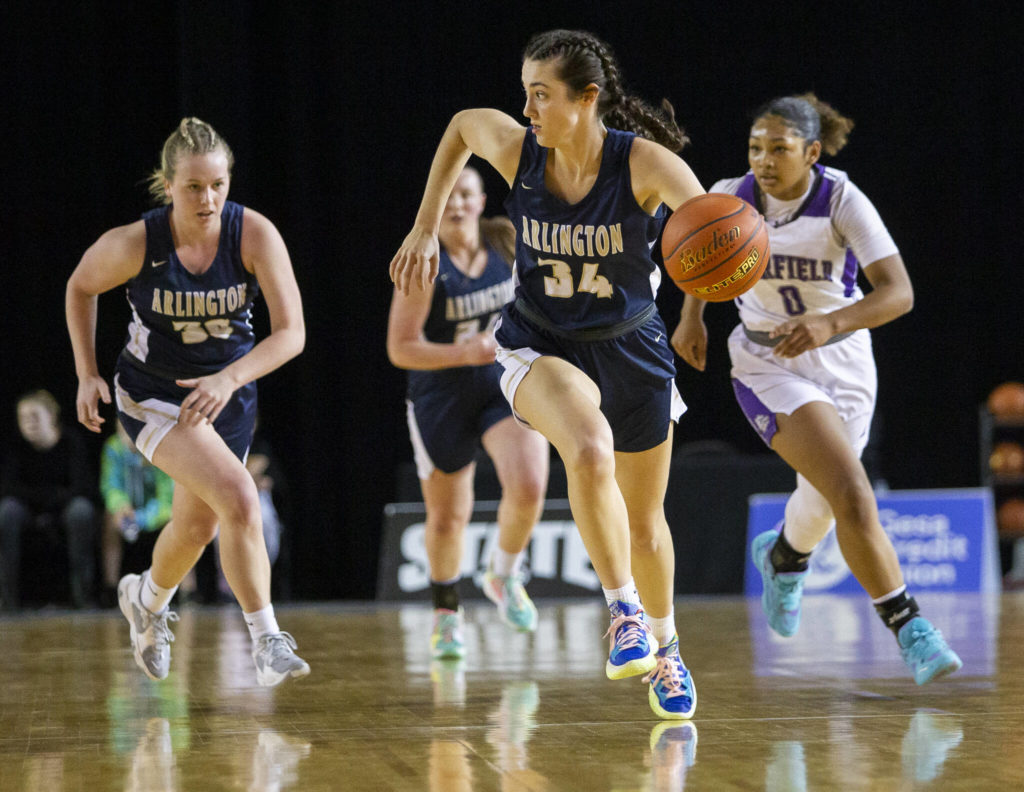 Arlington’s Jenna Villa looks for an open teammate after stealing the ball during a 3A state semifinal against Garfield at the Tacoma Dome on March 4. (Olivia Vanni / The Herald)
