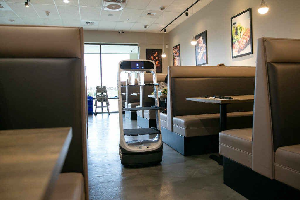 Peanut the server robot travels through the aisle to deliver water to a table at Sushi Hana on Jan. 5, in Lynnwood. (Ryan Berry / The Herald)
