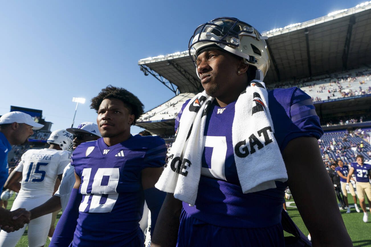 Washington quarterback Michael Penix Jr., right, walks on the field with safety Vincent Holmes (18) after a victory over Tulsa in an NCAA college football game Saturday, Sept. 9, 2023, in Seattle. (AP Photo/Lindsey Wasson)