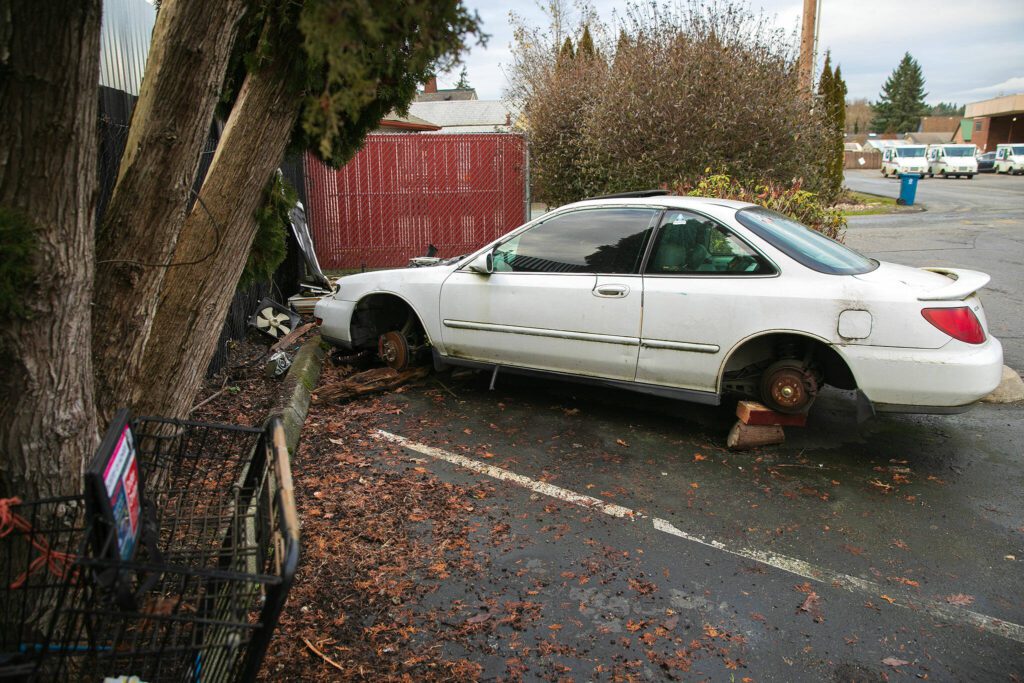 A vehicle long abandoned sits in the corner of the parking lot behind the old Union Bank on Wednesday, Jan. 3, 2024, in downtown Monroe, Washington. (Ryan Berry / The Herald)
