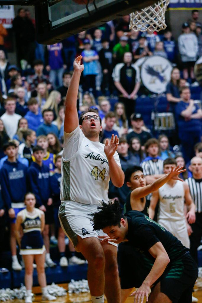 Arlington’s Billy Kooy scores from the post against Marysville Getchell during a playoff matchup at Arlington High School on Saturday, Feb. 24, 2024, in Arlington, Washington. (Ryan Berry / The Herald)
