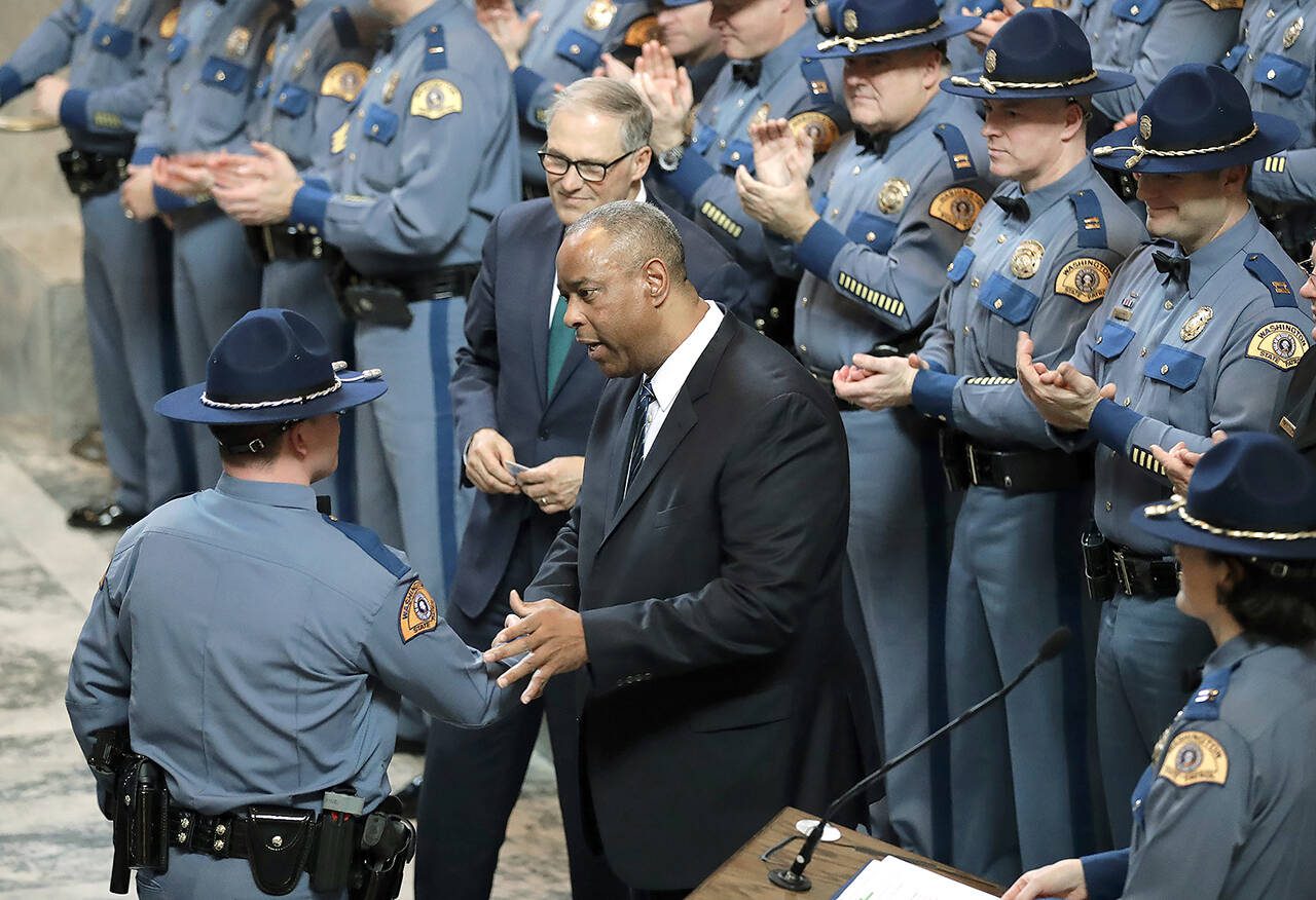 Washington State Patrol Chief John Batiste (center) greets a new trooper during a graduation ceremony, as Gov. Jay Inslee looks on in the Rotunda at the Capitol in December 2018, in Olympia. Batiste is among those seeking a reduction of the blood alcohol level for drivers to 0.05 percent. (Ted S. Warren / Associated Press file photo)