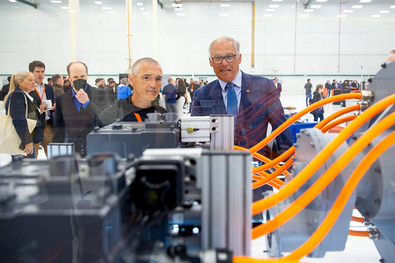 ZeroAvia founder and CEO Val Mifthakof, left, shows Gov. Jay Inslee a hydrogen-powered motor during an event at ZeroAvia’s new Everett facility on Wednesday, April 24, 2024, near Paine Field in Everett, Washington. (Ryan Berry / The Herald)