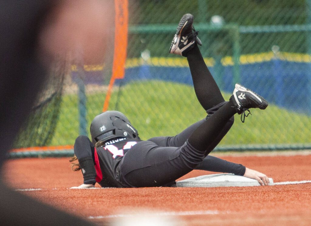 Snohomish’s Madalynn Larsen grabs onto third base to avoid sliding past it during the 3A state softball semifinal game against Garfield on Saturday, May 25, 2024 in Lacey, Washington. (Olivia Vanni / The Herald)
