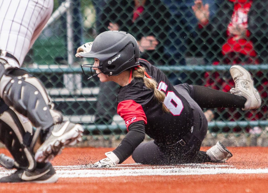 A Snohomish player slides into home to score a run during the 3A state softball semifinal game against Garfield on Saturday, May 25, 2024 in Lacey, Washington. (Olivia Vanni / The Herald)

