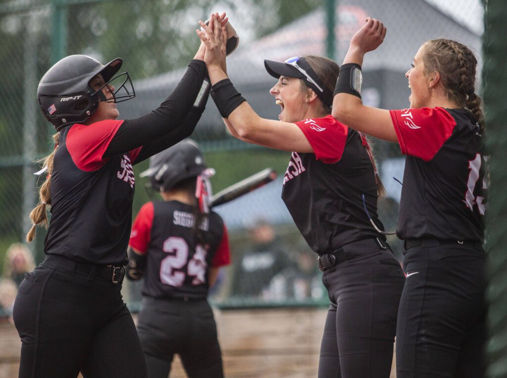 Snohomish players high-five after scoring during the 3A state softball championship game against Auburn Riverside on Saturday, May 25, 2024 in Lacey, Washington. (Olivia Vanni / The Herald)
