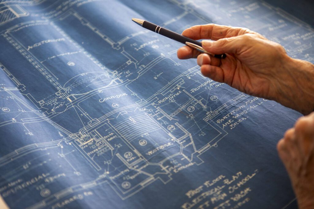 Lawrence E. O’Donnell looks at blueprints of Everett High School at his brother Jack’s home in Everett, Washington on Wednesday, May 29, 2024. (Annie Barker / The Herald)
