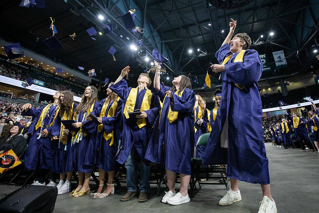Grauates throw their caps in the air at the end of Arlington High School graduation at Angel of the Winds Arena on Thursday, June 13, 2024 in Everett, Washington. (Olivia Vanni / The Herald)