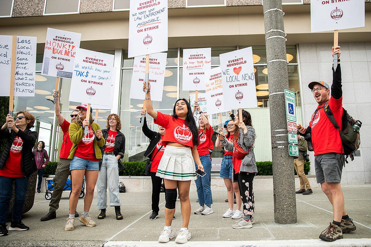 Everett NewsGuild members cheer as a passing car honks in support of their strike on Monday, June 24, 2024 in Everett, Washington. (Olivia Vanni / The Herald)