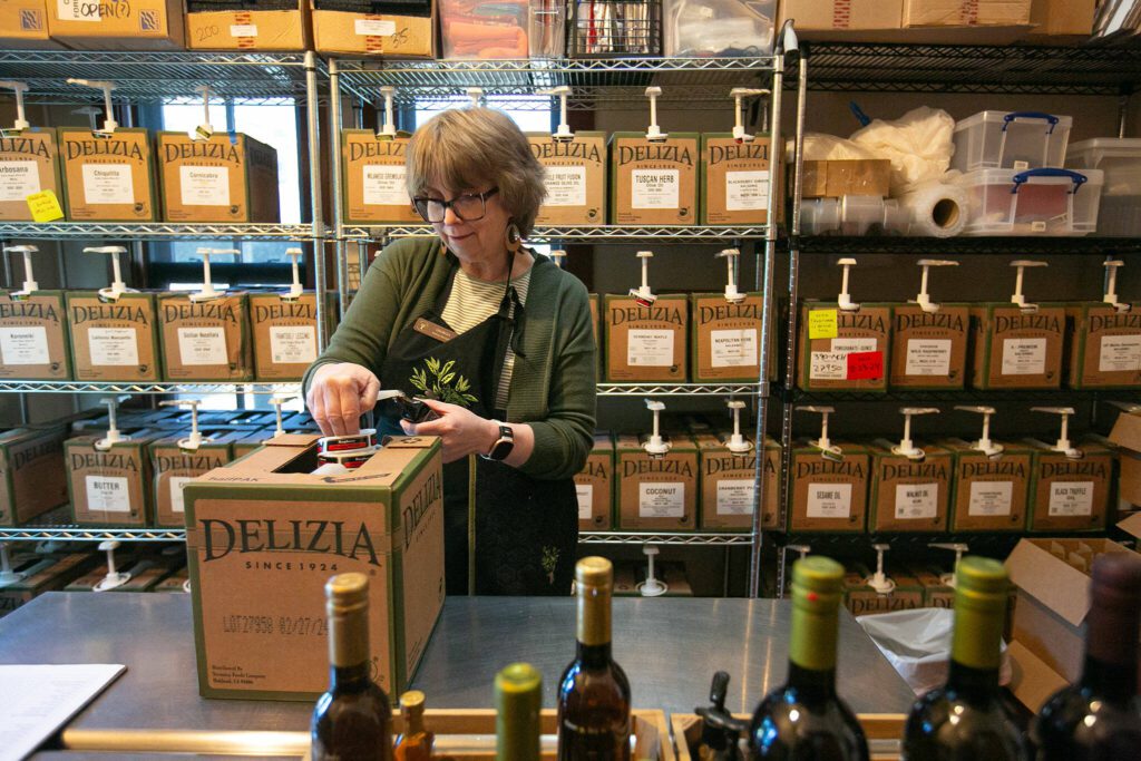 Georgia Spencer, an employee since December, fills and restocks bottles of olive oil and balsamic vinegar at A Bit of Taste on Wednesday, June 12, 2024, in Snohomish, Washington. (Ryan Berry / The Herald)
