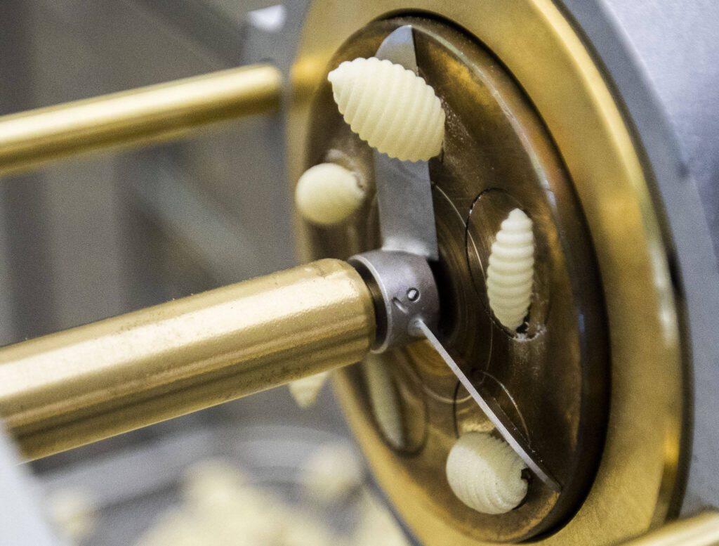 Fresh cavatelli is pushed out of pasta die and cut at Wildly Beloved Foods on Thursday, June 27, 2024 in Clinton, Washington. (Olivia Vanni / The Herald)
