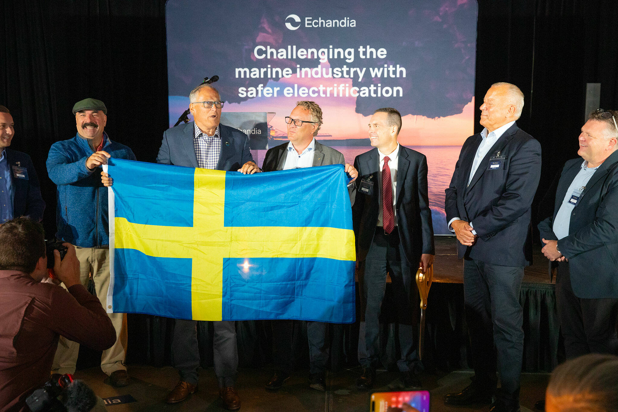 Gov. Jay Inslee presents CEO Fredrik Hellstrom with the Swedish flag during a grand opening ceremony for Sweden-based Echandia on Tuesday, July 30, 2024, in Marysville, Washington. (Ryan Berry / The Herald)