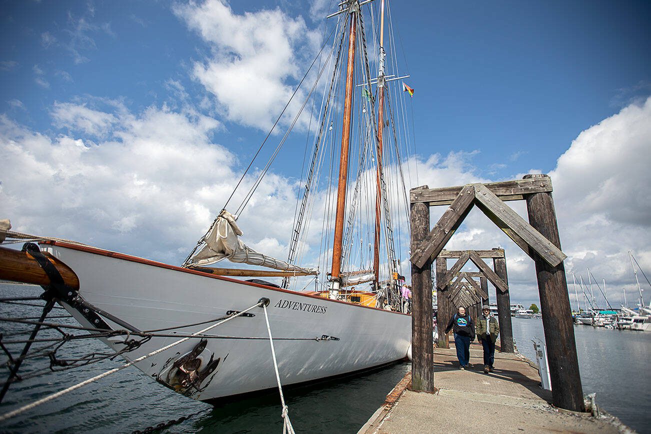 People walk by the Adventuress docked at the Port of Everett on Tuesday, Aug. 27, 2024 in Everett, Washington. (Olivia Vanni / The Herald)