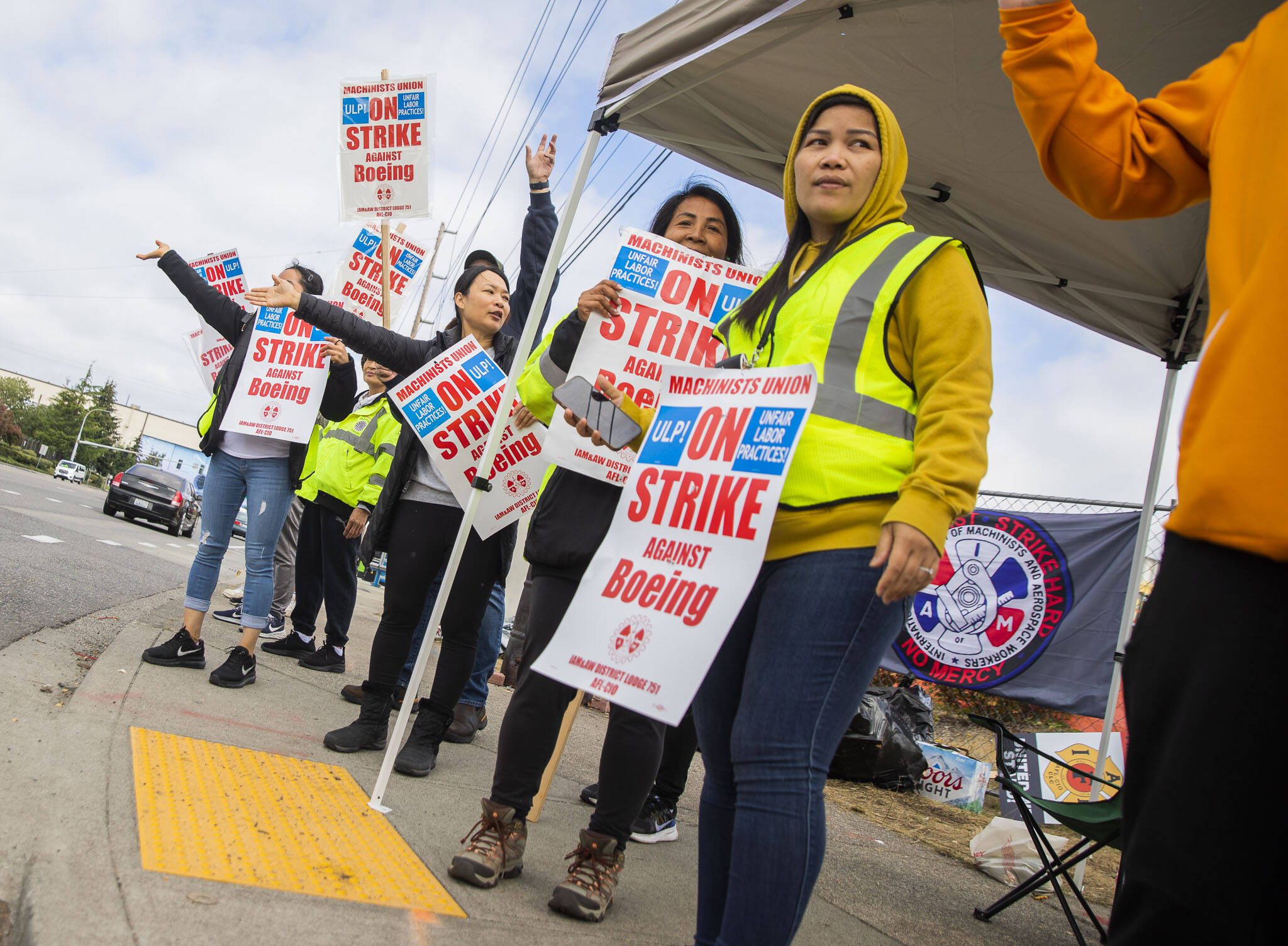 Nory Hang, right, watches cars pass by while picketing with fellow Boeing workers on strike along Airport Road on Monday, Sept. 16, 2024, in Everett, Washington. (Olivia Vanni / The Herald)