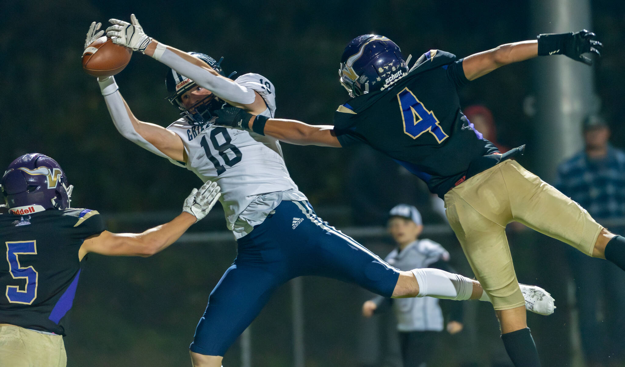 Glacier Peak’s Zachary Albright attempts to pull in a touchdown pass between Lake Stevens’ Treyten Pester (5) and Seth Price (4) in Lake Stevens, Wash., on Friday, Oct. 4, 2024. The game ended 31-10, and the Vikings handed the Grizzlies their first loss of the season. (John Gardner / Pro Action Image)