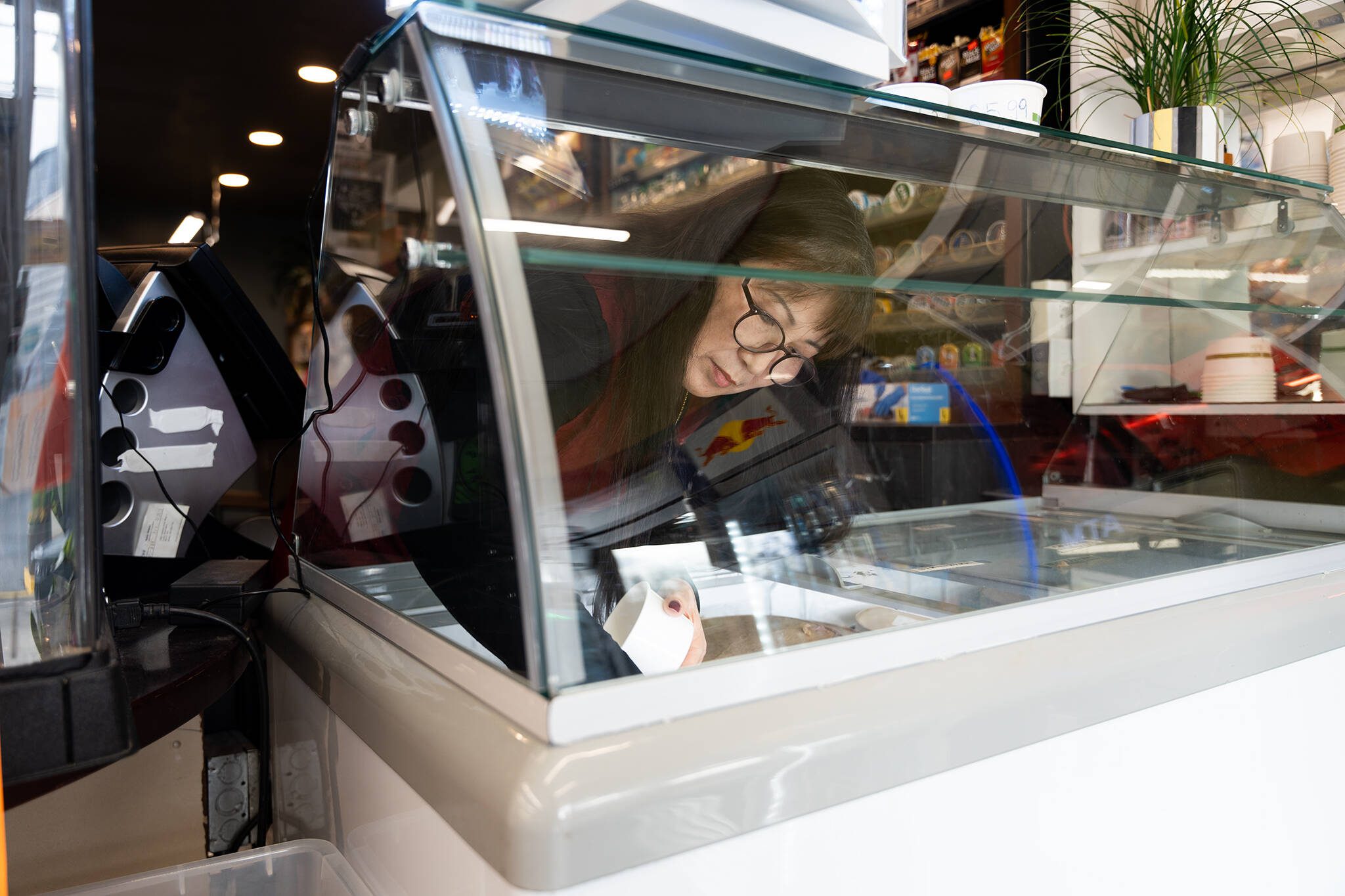 Lia Tetreault serves strawberry ice cream to a customer at the Soundview Deli on Monday, Nov. 18, 2024, in Everett, Washington. (Will Geschke / The Herald)