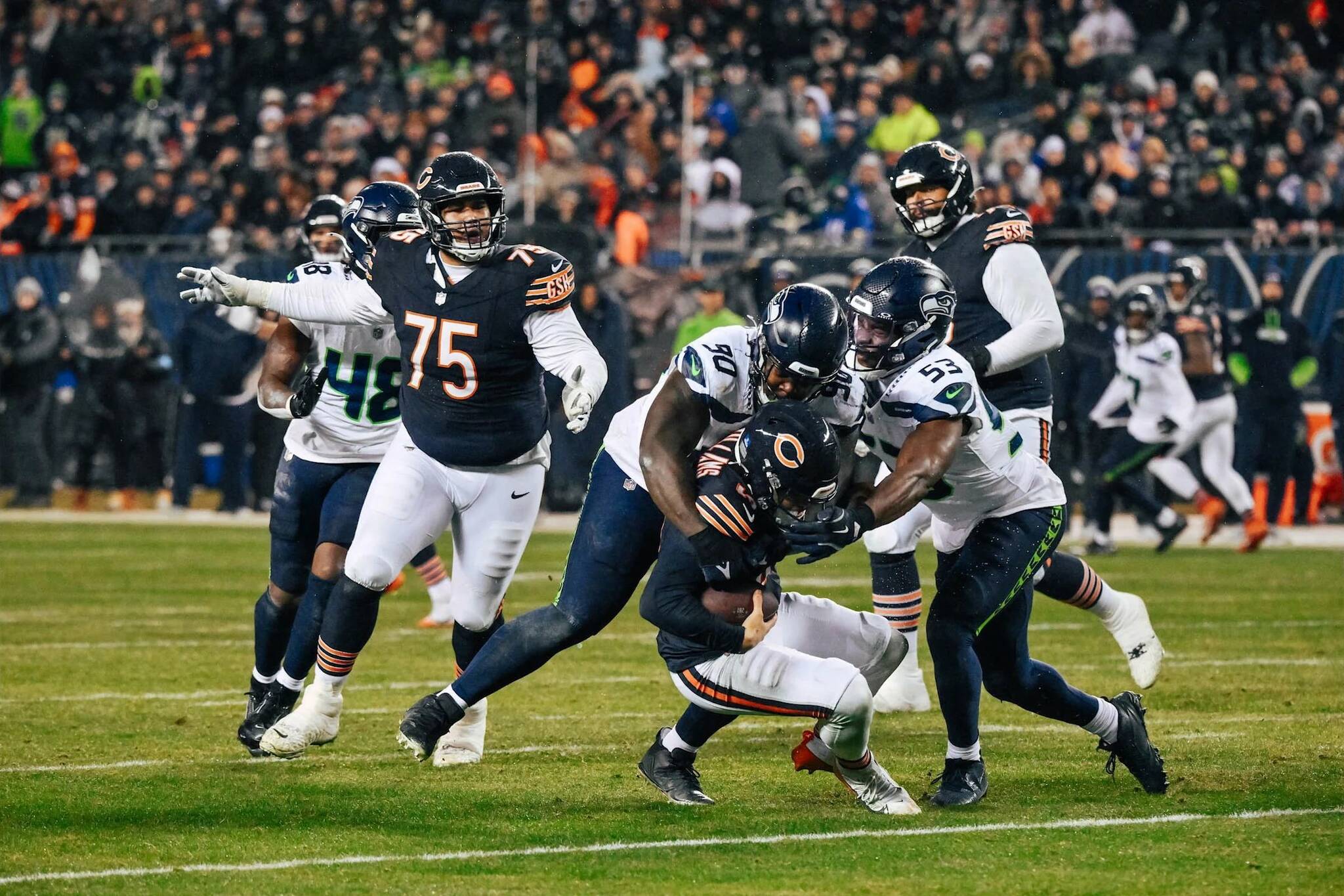 Seahawks nose tackle Jarran Reed (90) sacks Chicago Bears quarterback Caleb Williams (18) as Seahawks linebacker Boye Mafe closes in at Soldier Field on Thursday, Dec. 26, 2024. (Photo courtesy of Edwin Hooper / Seattle Seahawks)