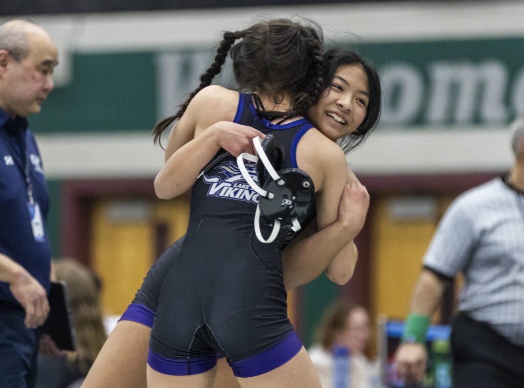 Lake Stevens’ Lily Ganal receives a hug from a teammate after beating Glacier Peak’s Eliana Sherve in the 130-pound match at the 4A girls wrestling district tournament on Friday, Feb. 7, 2025 in Mill Creek, Washington. (Olivia Vanni / The Herald)
