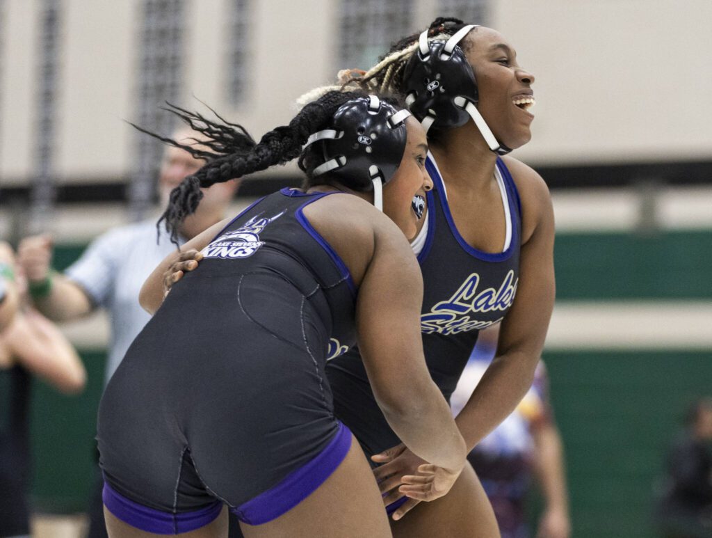 Lake Stevens teammates Afedbia Aemere and Alex Harris smile and laugh together after wrestling each other in the 155-pound match at the 4A girls wrestling district tournament on Friday, Feb. 7, 2025 in Mill Creek, Washington. (Olivia Vanni / The Herald)
