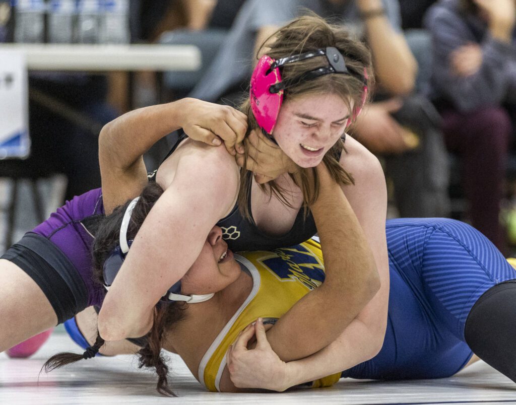 Lake Stevens’ Kylee Wicklund grimaces as she tries to push Mariner’s Jannethzy Cortes-Hernandez into the mat during the 140-pound match at the 4A girls wrestling district tournament on Friday, Feb. 7, 2025 in Mill Creek, Washington. (Olivia Vanni / The Herald)
