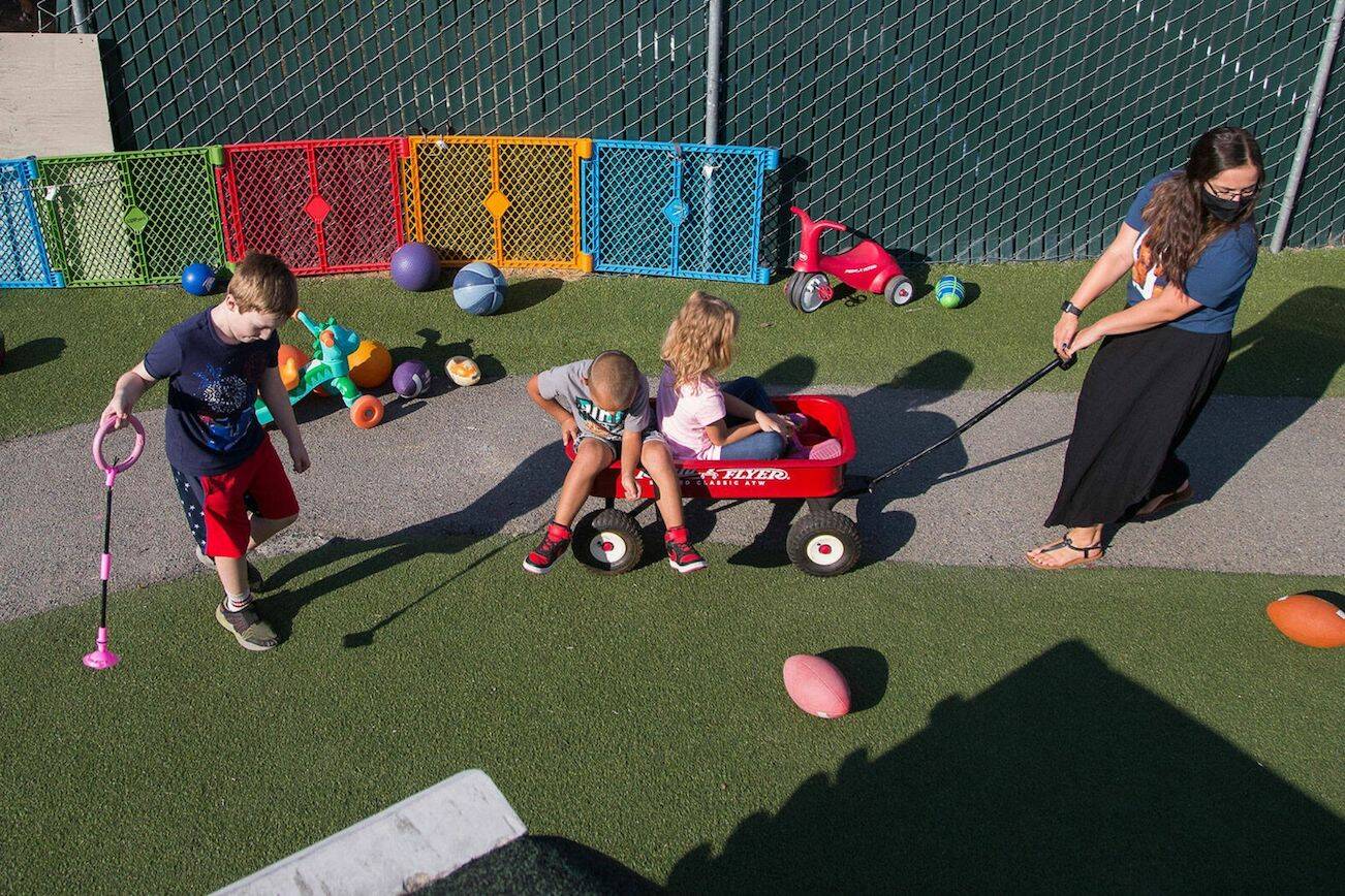 Emilee Swenson pulls kids around in a wagon at HopeWorks' child care center Tomorrow’s Hope, a job training program for people interested in child care, on Tuesday, Sept. 7, 2021 in Everett, Washington. HopeWorks is one of the organizations reciving funding from the ARPA $4.3 million stipend. (Andy Bronson / The Herald)